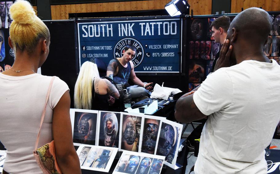 A group of Americans watch a U.S. soldier get tatooed at the Tattoo Expo Grafenwoehr, in Grafenwoehr, Germany, Sunday, April 15, 2018. Taylor ended up winning best color tattoo.