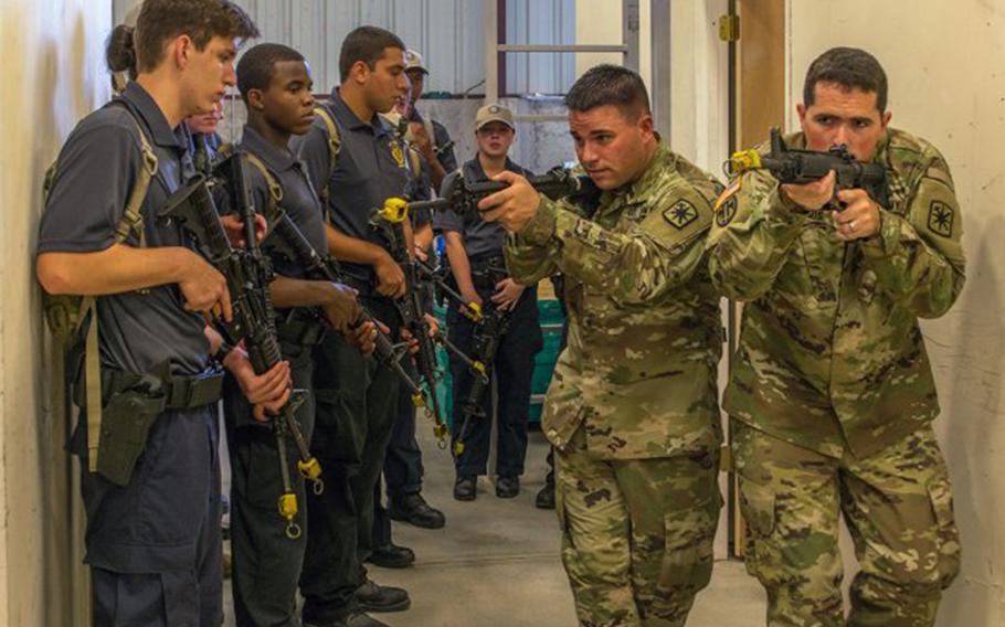 Instructors with the 14th Military Police Brigade demonstrate proper room clearing techniques to explorers during the Bi-Annual National Law Enforcement Explorers Academy. A member of the brigade at Fort Leonard Wood, Mo. has been granted religious accommodation to have a beard because of his of the Norse Pagan faith.