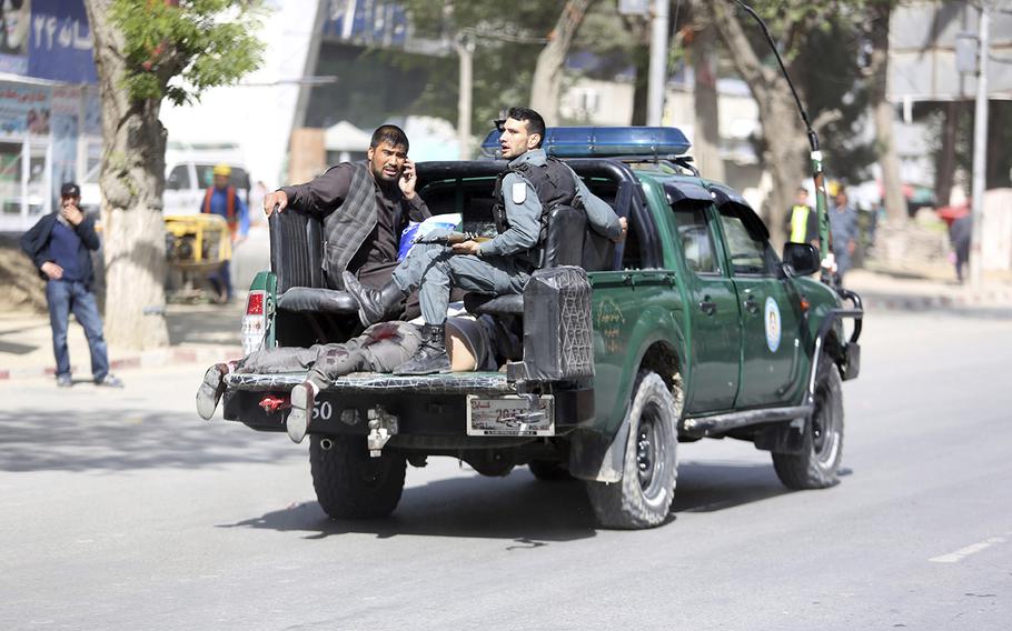 Afghan security personnel carry a victim after the second blast in Kabul, Afghanistan, Monday, April 30, 2018. A coordinated double suicide bombing hit central Kabul on Monday morning.