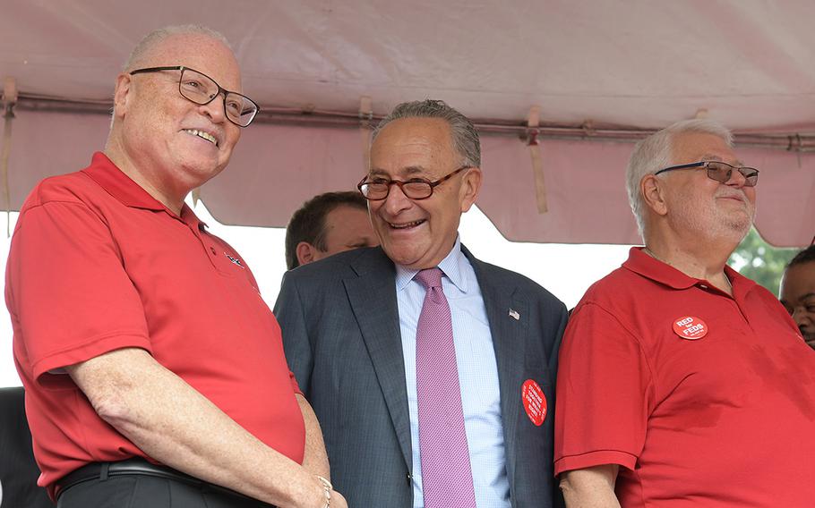 Sen. Chuck Schumer, D-N.Y., (center) on stage during a rally for the American Federation of Government Employees on July 25, 2018 in Washington, D.C.