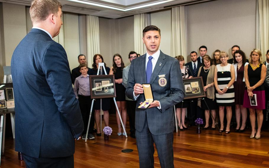 Aleks Morosky, the National Legislative Director of the Military Order of the Purple Heart, presents a recently discovered medal to Purple Hearts Reunited founder Army National Guard Maj. Zacharia Fike during a ceremony in Washington D.C. on Purple Heart Day on Tuesday, Aug. 7, 2018.