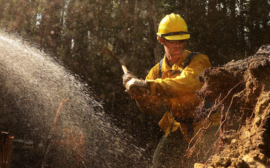 Washington Air National Guard Master Sgt. Luke Anderson, 141st Communications Squadron mops up an area of the Sheep Creek fire Aug. 6, 2018, near Northport, Wash. 