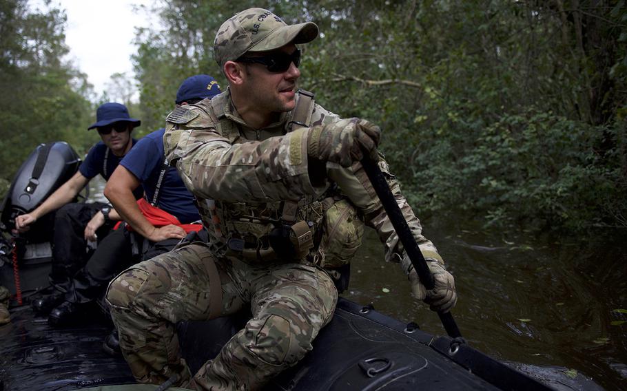 A member of Coast Guard Tactical Law Enforcement Team South rows a shallow-water craft through debris filled water while conducting Hurricane Florence search and rescue operations in Brunswick County, North Carolina, Sept. 17, 2018. 