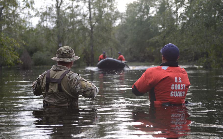 Members of Coast Guard Maritime Safety and Security Team Miami and Coast Guard Tactical Law Enforcement Team South wait to be picked up by their rescue team after completing Hurricane Florence search and rescue operations in Brunswick County, North Carolina, Sept. 16, 2018. 



The Coast Guard is conducting search and rescue operations in support of state and local emergency operation centers



U.S. Coast Guard photo by Petty Officer 3rd Class Trevor Lilburn.