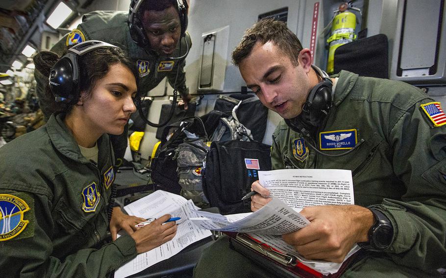 U.S. Air Force Tech. Sgt. Rocco L. Morello, right, reviews a mission accomplishment report sheet with Senior Airman Darius L. Wilson, center, and Senior Airman Stephanie Lezcano during a joint training mission among aeromedical evacuation technicians over the United States Oct. 5, 2018. 