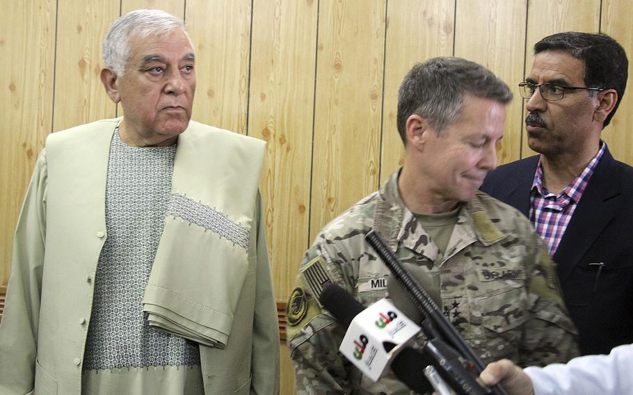 Kandahar Gov. Zalmay Wesa, left, stands with the head of NATO troops in Afghanistan, Gen. Scott Miller, center, and a translator, during a meeting, in Kandahar, Afghanistan, Thursday, Oct. 18, 2018. Wesa was among three top officials in Afghanistan's Kandahar province who were killed when their own guards opened fire on them at the security conference, the deputy provincial governor said. A Taliban spokesman said the target was Miller, who escaped without injury, according to NATO.
