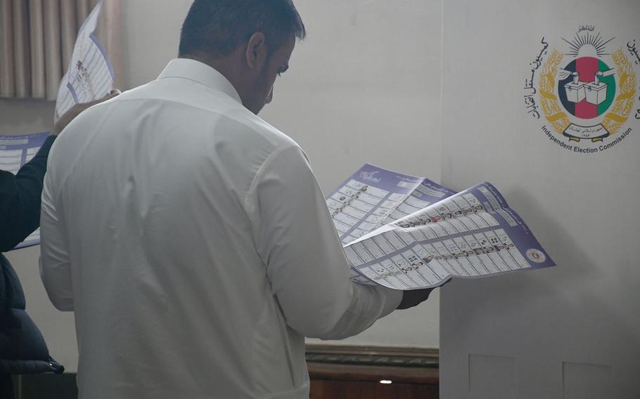 A man scans a ballot for parliamentary candidates in Kabul on Sunday, Oct. 21, 2018.