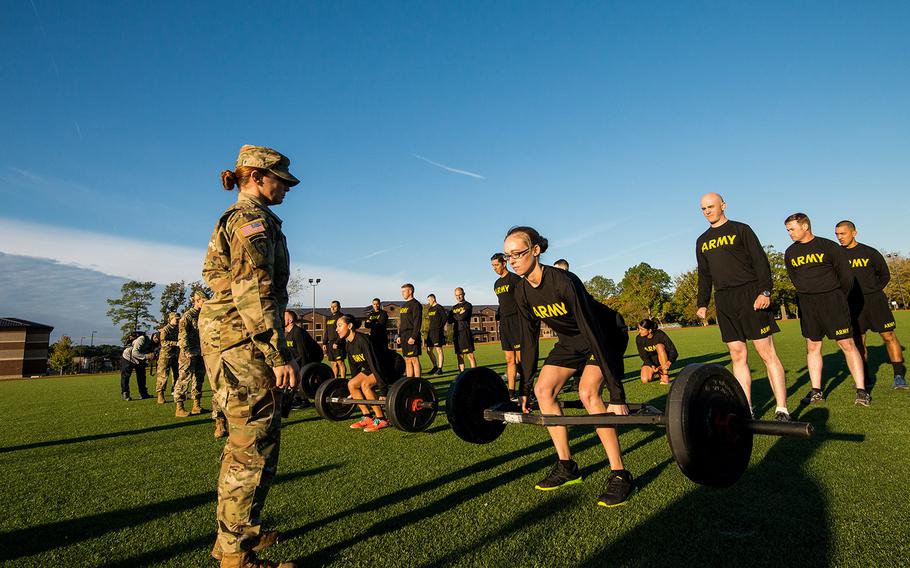 Army Staff Sgt. Jessica Smiley, a test grader with the Army's Center for Initial Military Training, looks on as soldiers with the 128th Aviation Brigade at Fort Eustis, Va., demonstrate the deadlift, the first of six events of the new Army Combat Fitness Test on Oct. 23, 2018.