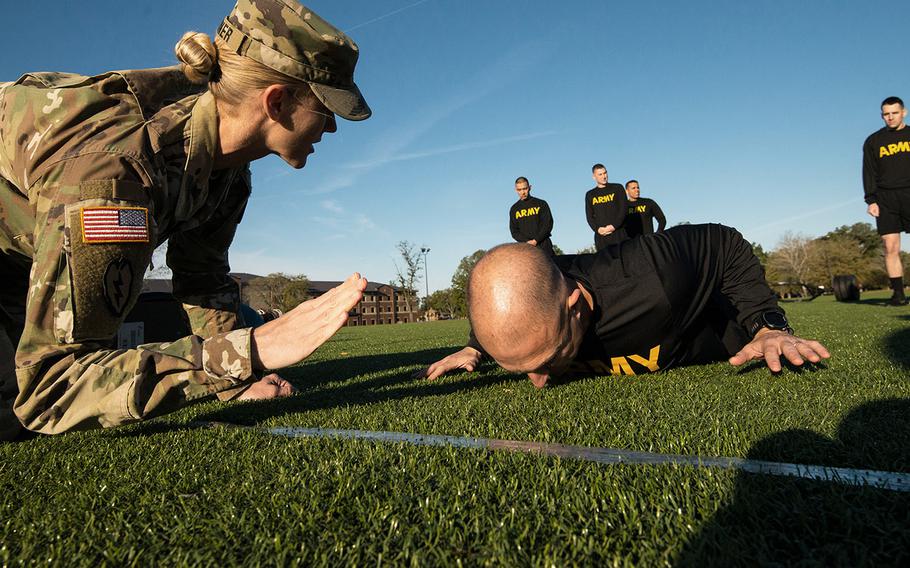 Army Master Sgt. Shelley Horner grades a 128th Aviation Brigade attempting the hand release pushup portion of the Army's new Army Combat Fitness Test during a demonstration of the new test on Tuesday, Oct. 23, 2018 at Fort Eustis, Va.