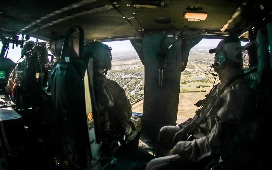 A crew chief and pilot assigned to 2nd Assault Helicopter Battalion, 82nd Combat Aviation Brigade, 82nd Airborne Division and Customs and Border Protection agent observe the South Texas Border during a routine patrol flight in Rio Grande Valley during border support operations, Dec. 1, 2018.