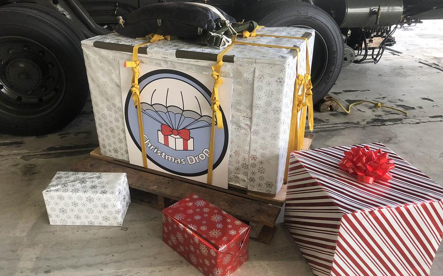 A box of Operation Christmas Drop donations was wrapped in Christmas paper for a special ceremony for servicemembers, volunteers and regional leaders. 