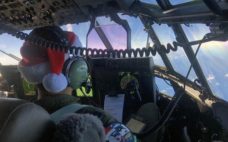 A C-130 pilot wears a Santa hat and an Operation Christmas Drop patch during a flight over the Northern Marianas Islands. 