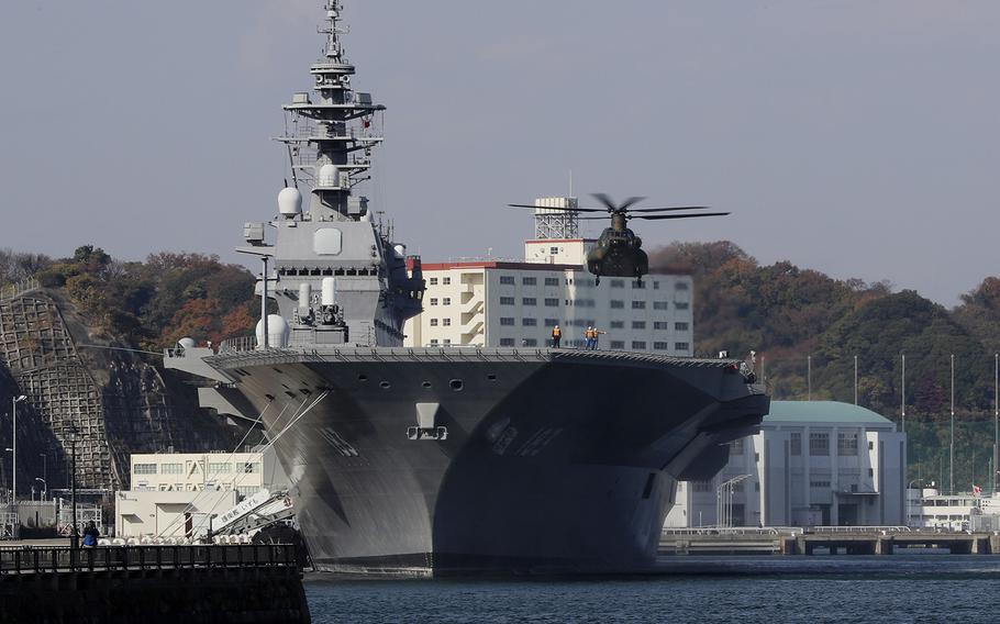 A helicopter prepares to land on the flight deck of the destroyer Izumo of Japan's Maritime Self-Defense Force in Yokosuka, Japan on Dec. 6, 2016.