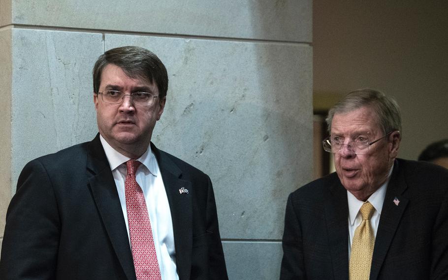 Veterans Affairs Secretary Robert Wilkie looks away after greeting Chairman of the Senate Veterans Affairs Committee Johnny Isakson, R-Ga., prior to the start of a hearing on Capitol Hill in Washington on Wednesday, Dec. 19, 2018.