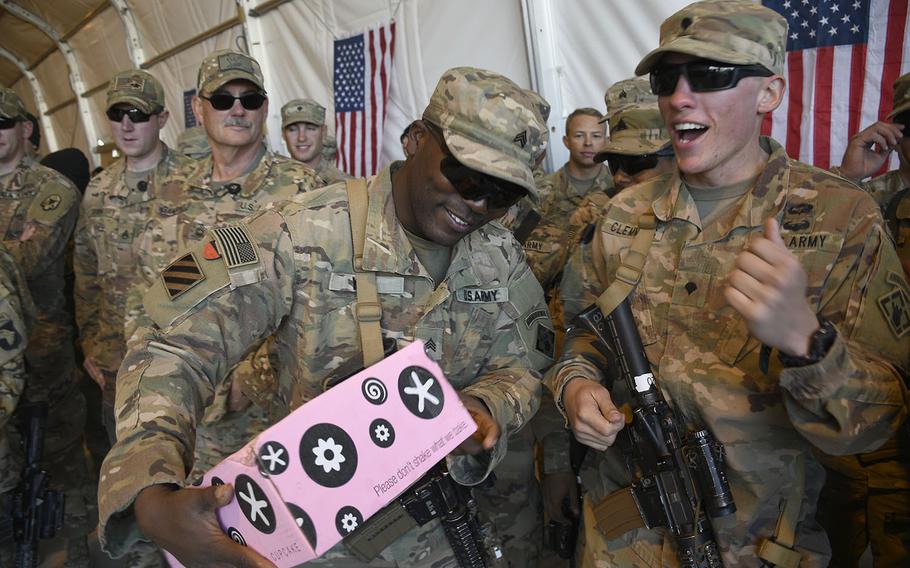 Soldiers of the 264th Engineer Clearance Company celebrate the arrival of artisanal cupcakes sent to them at the remote Camp Dahlke West in Afghanistan during a Christmas event with the USO on Monday, Dec. 24, 2018.