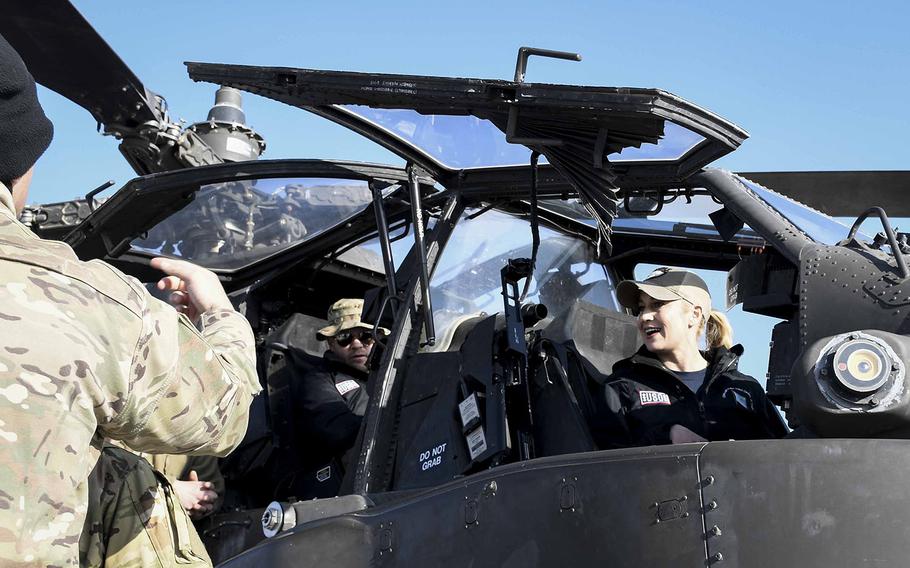 Country musician Kellie Pickler sits in the cockpit of an AH-64 Apache attack helicopter at a Christmas event with the USO on Monday, Dec. 24, 2018, at Camp Dahlke West in Afghanistan. 
