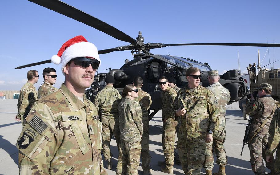 Spc. Adam Wells, 25, an armament soldier with the 4th Battalion (Attack Reconnaissance), 4th Aviation Regiment, watches as celebrities inspect his AH-64 Apache attack helicopter at a Christmas event with the USO on Monday, Dec. 24, 2018, at Camp Dahlke West in Afghanistan. 
