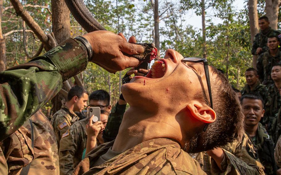 Royal Thai Armed Forces Master Sgt. 1st Class Saengchai Seeuthai pours cobra blood into the mouth of a U.S. soldier of the 20th Infantry Regiment during exercise Cobra Gold 19 at Phitsanulok, Thailand, on Feb. 13, 2019.