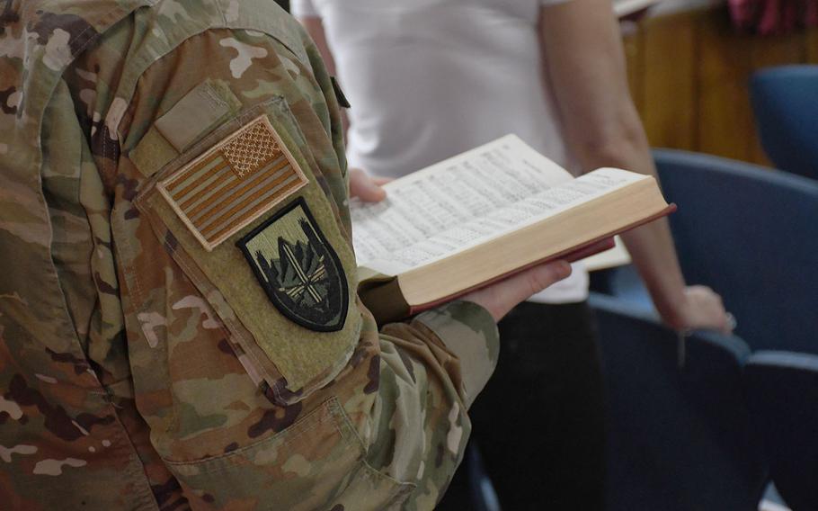 An American servicemember sings from a hymn book during an Easter service at NATO's Resolute Support headquarters in Kabul, Afghanistan, on Sunday, April 21, 2019.