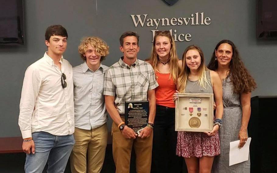 The parents and siblings of Riley Howell hold a plaque and framed medals that were presented from the Waynesville, N.C., Police Department and Haywood County Sheriff Greg Christopher. The medals were donated by Marine Corps veteran Thomas “Stormy” Matteo.