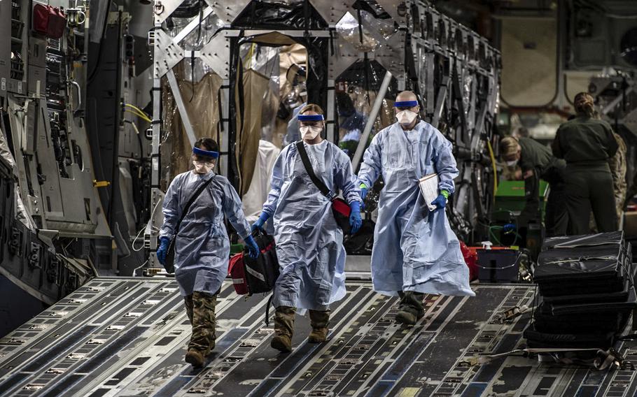 Three medical airmen exit a C-17 Globemaster III aircraft at Ramstein Air Base, Germany, April 10, 2020, following the first-ever operational use of the Transport Isolation System. The TIS is an infectious disease containment unit designed to minimize contamination risk to aircrew and medical attendants while allowing in-flight medical care for patients with an infectious disease -- in this case, COVID-19.

