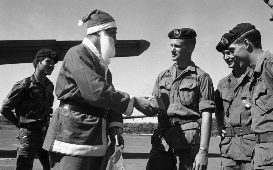 Santa Claus hands out presents to the men of Detachment 35, Company B, 5th Special Forces Group, in Vietnam at the end of 1968. The Air Force lent Santa six C7 Caribou cargo planes for his deliveries in Vietnam. The planes enabled him to visit some 50 isolated outposts — such as this Special Forces camp in Nhon Cho, 80 miles northeast of Saigon — from Dec. 24 until late in the afternoon Christmas day. 