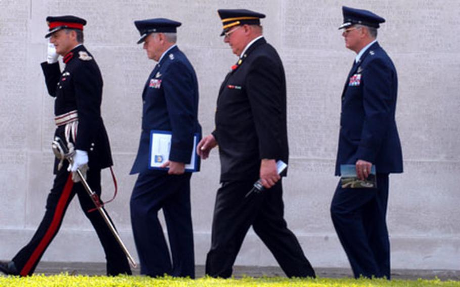 The official party arrives Monday for the Memorial Day ceremony at the Cambridge American Cemetery in Madingly, England. They pass the Wall of the Missing, which holds more than 5,000 names of missing U.S. service members from World War II.
