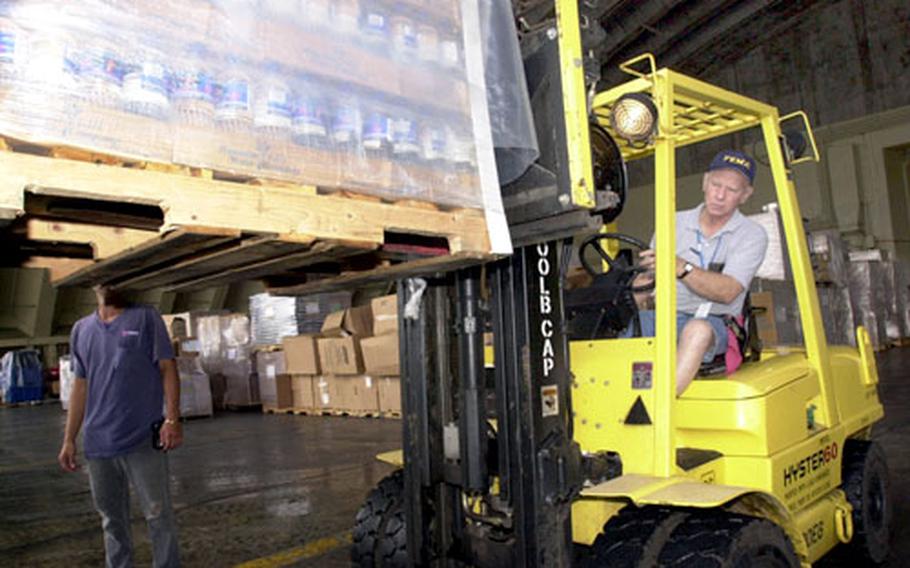 Robert Love from FEMA loads bottled water ONTO a truck at Andersen Air Force Base, Guam.