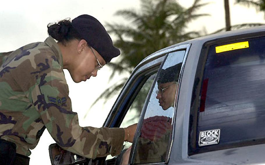 Airman 1st Class Octavia Hall, from Yokota Air Base’s 374th Security Forces Squadron, checks IDs at the front gate of Andersen Air Force Base, Guam.