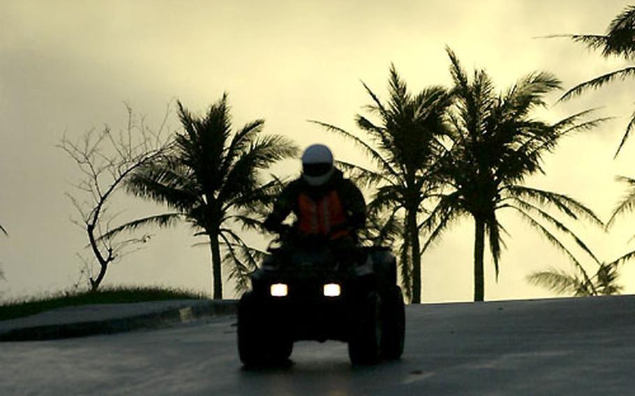 As the day begins on Guam, Staff Sgt. Henry Freeman, from Yokota&#39;s 374th Security Forces Squadron, patrols an Andersen Air Force Base housing area on an ATV.