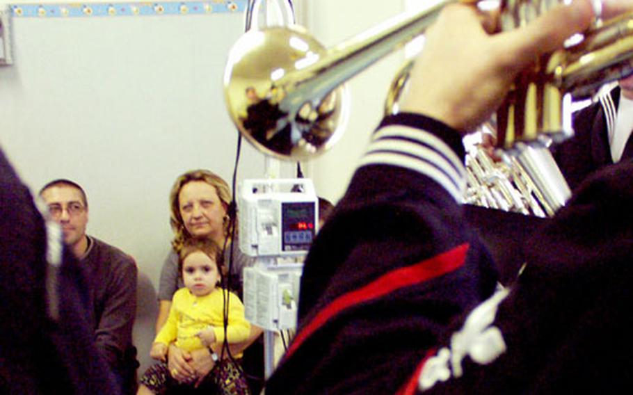 Sixth Fleet band sailors play holiday tunes Wednesday for Italian hospital patients, including 11-month-old Tanya.