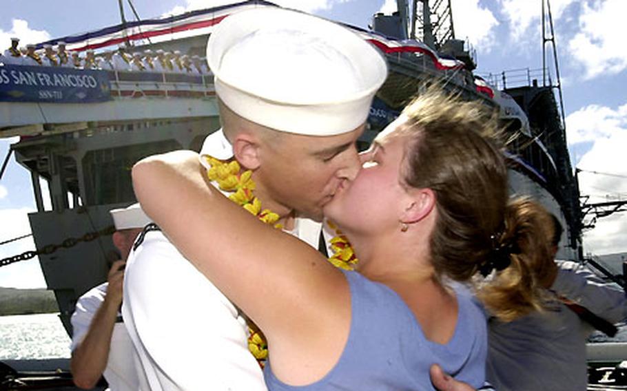 Petty Officer 1st Class Paul Sweeney, a crewmember aboard the submarine USS San Francisco, gives his wife, Summer, a big kiss Wednesday on the pier in Guam.