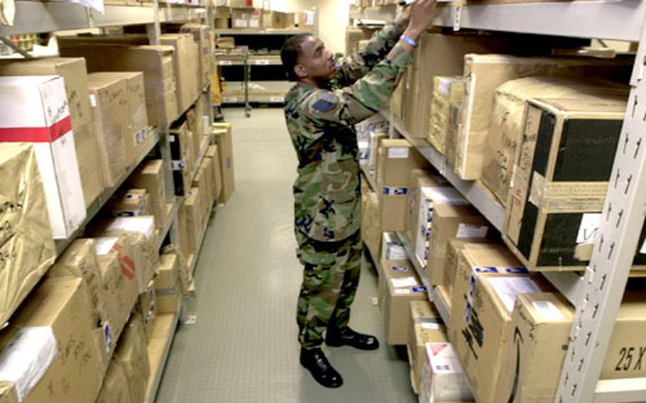 Tech. Sgt. Will Smith, Rhein-Main Air Base postmaster, sorts incoming packages at the Rhein-Main Post Office on Friday.