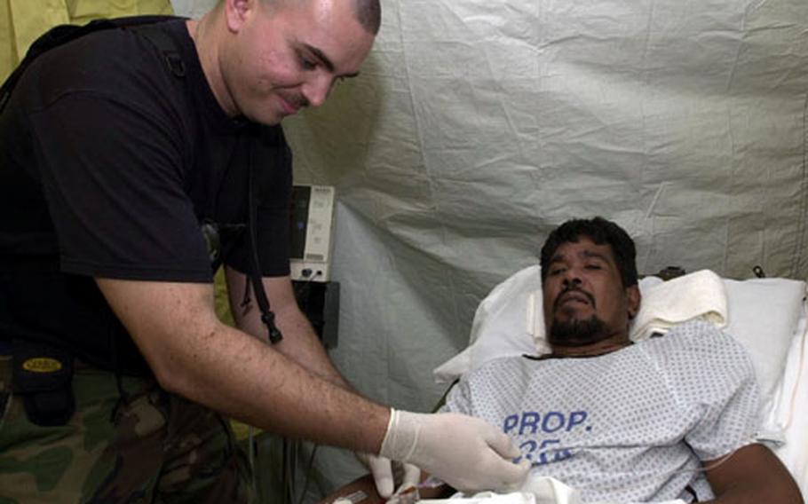 Staff Sgt. Foye Flowers flushes out a patient&#39;s IV at the field hospital put up by Yokota&#39;s 374th Medical Group outside Guam&#39;s only civilian hospital.