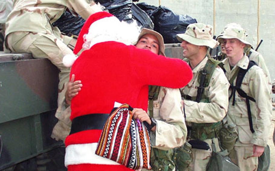 Marine Corp. Ted Lachance hugs Santa Claus, played by Maj. Mike Riddle. Members of the I Marine Expeditionary Force in Kuwait received gifts donated by an American couple&#39;s program called Operation Christmas Basket.