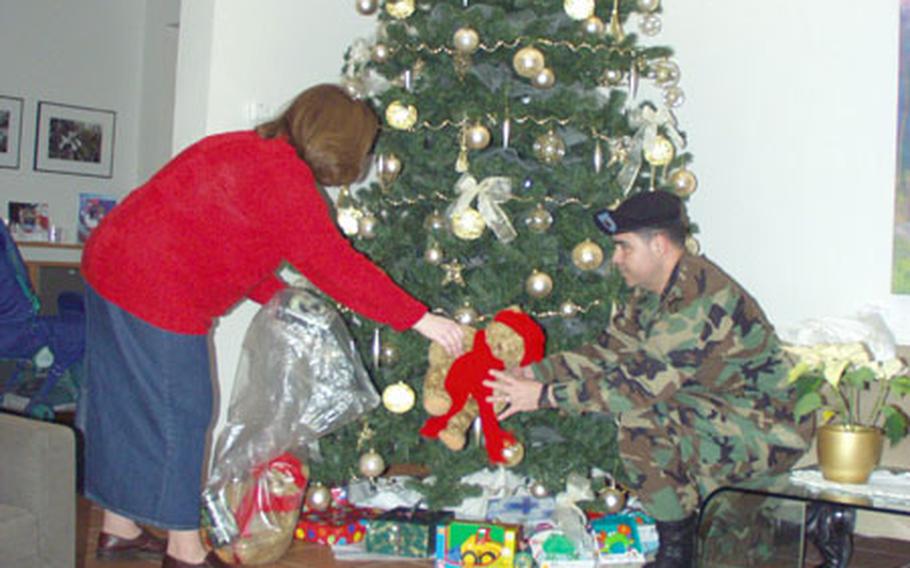 Beth Duncan, the 415th Base Support Battalion’s Holiday Outreach Program officer, and Command Sgt. Maj. Daniel Chavez, the battalion’s top enlisted soldier, place extra toys under the Landstuhl Regional Medical Center’s Fisher House Christmas tree Tuesday. Volunteers planned on presenting the toys to children at the hospital and house, but the children were still asleep in their beds. There were no reports as to whether visions of sugar plums were dancing in their heads.