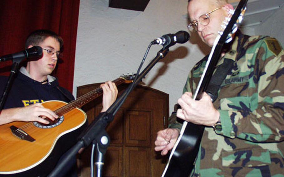 Lt. Col. Mike Lembke, right, an Army chaplain in Schweinfurt, Germany, has composed more than 400 songs in the past quarter century, and he plays them frequently for his military congregations. He and his son, Mike Jr., 16, left, have their own garage band that performs frequently with soldier/musicians as guests.