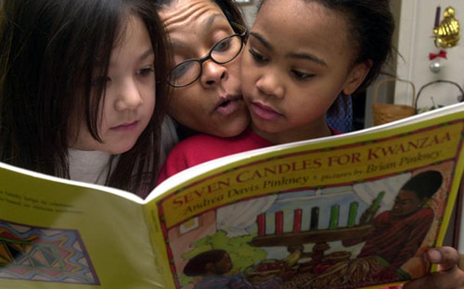 D&#39;Juana Cephus (center) reads a book about Kwanzaa on Friday with her 8-year-old daughter, Raquel, right, and Raquel&#39;s friend, Azlyn Heidt, also 8, at Cephus&#39; home in the Sagamihara Housing Area near Camp Zama, Japan.