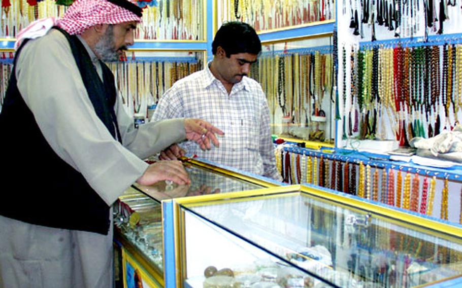 A Kuwaiti man shops for prayer beads in a store in Kuwait City&#39;s souk in the city center.