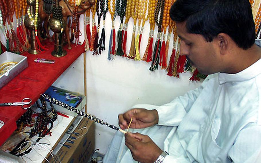 Mohammed Ansar Addir makes prayer beads in a store in Kuwait City&#39;s souk.