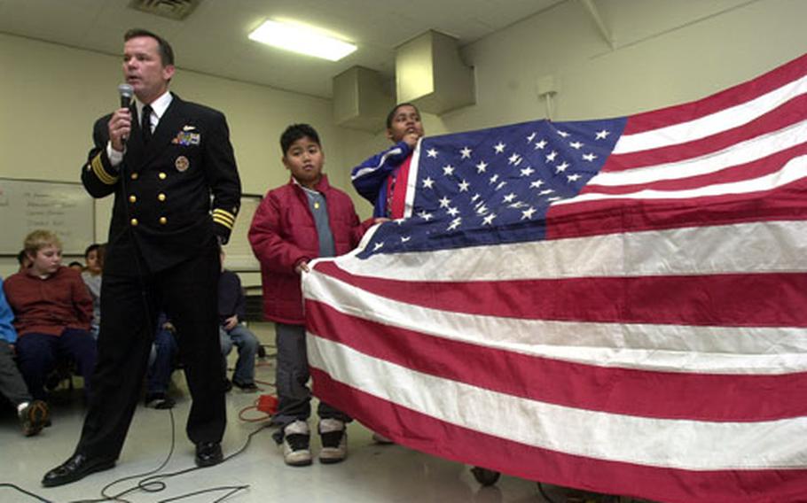 Cmdr. Seamus Flatley, commanding officer of Fighter Squadron 154, talks about Old Glory, a special American flag on a world tour, Friday at Shirley Lanham Elementary School on Naval Air Facility Atsugi, Japan.