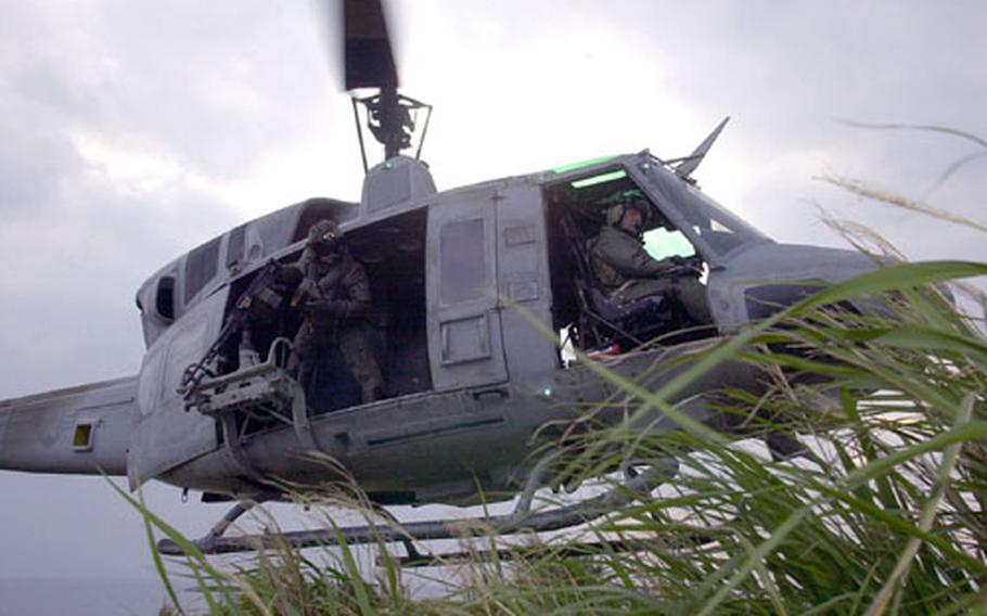 Pilots and crews of a UH-1N Huey lift off after inserting an infantry team off the coast of Okinawa. Marines from Marine Light Attack Squadron 367 practiced dropping off and picking up infantry while under fire.