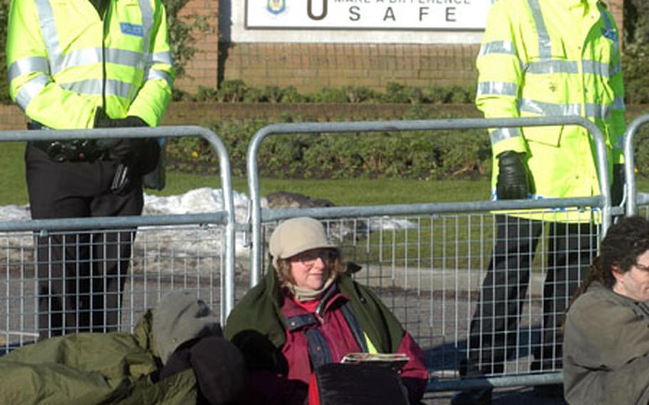 Protesters rest peacefully outside the gate at RAF Lakenheath, England, during a demonstration Monday to protest the possible outbreak of war on Iraq. About 70 demonstrators and a couple of dozen police stood in a cold wind during the non-violent action.