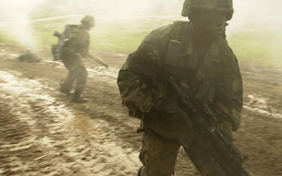 Camp Hovey-based soldiers move along a muddy road as thick smoke obscures them during a live-fire training exercise at Rodriguez Range, South Korea, in this undated file photo.