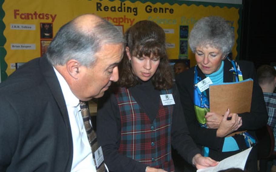 Deb Aiken, center, a teacher at Alconbury High School in England, discusses student efforts Monday with Joseph Tafoya, left, director of the Department of Defense Education Activity, and Diana Ohman, director of Department of Defense Dependent Schools in Europe.