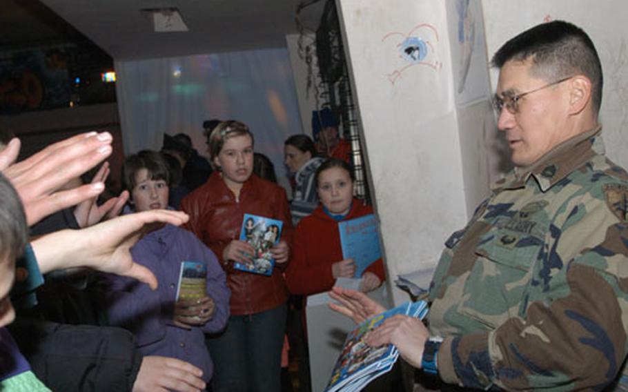 Sgt. 1st Class Carl Bjornstal of 13th PSYOPS Battalion gives Mirko magazine, notebooks, posters and coloring books to teens gathered at Pinkland youth center in Banovici, Bosnia and Herzegovina, for a party on Valentine&#39;s day.