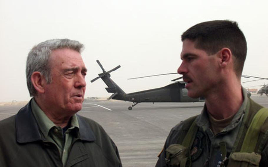 CBS News anchorman Dan Rather talks with Chief Warrant Officer 4 Jim Deppen, an Apache Longbow attack helicopter pilot from the 6th Squadron, 6th Cavalry Regiment from Illesheim, Germany. Deppen flew one of the Army&#39;s new Longbows for the network&#39;s camera crews this week.