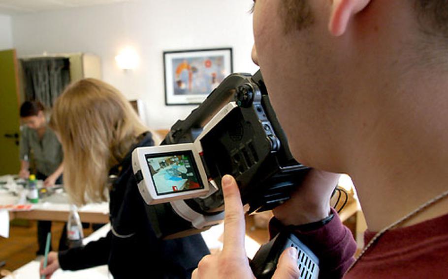 Evan Fillman of SHAPE High School, Belgium, participating in the "Video Production" workshop, focuses on the works being made in the "Sculpture: State of Mind" workshop.