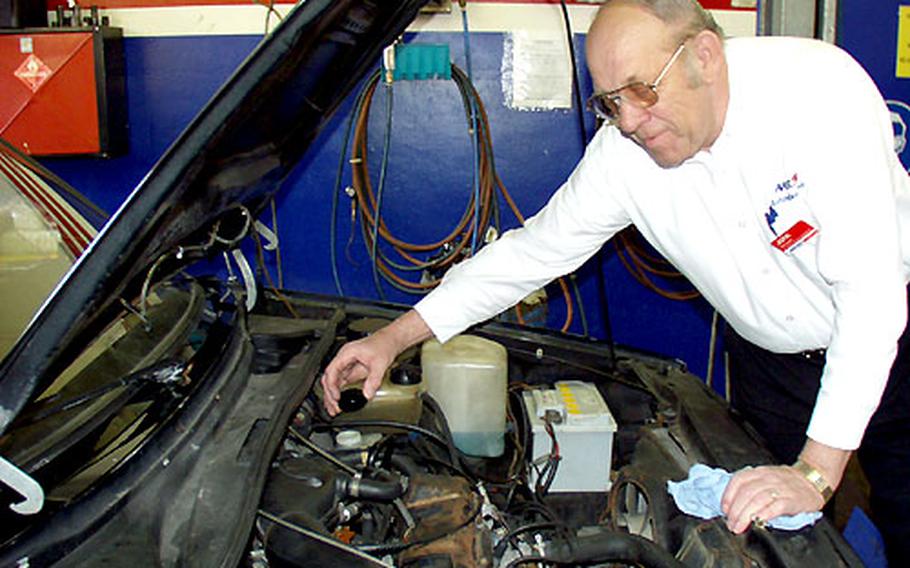 John Koltes, manager of the Car Care Center at Lincoln Village in Darmstadt, Germany, gives a free 18-point inspection. Koltes found three bolts missing on the exhaust of this VW Golf.