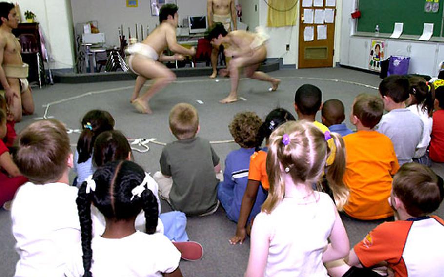 Volunteers demonstrate sumo wrestling to a kindergarten class.